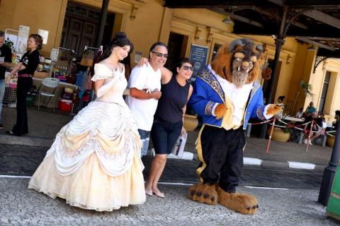 Casal tira foto com personagens A Bela e a Fera.