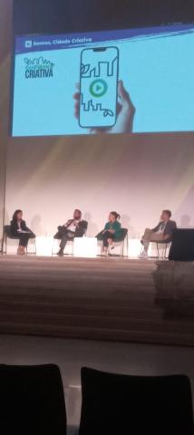 pessoas sentadas participando de fórum #paratodosverem