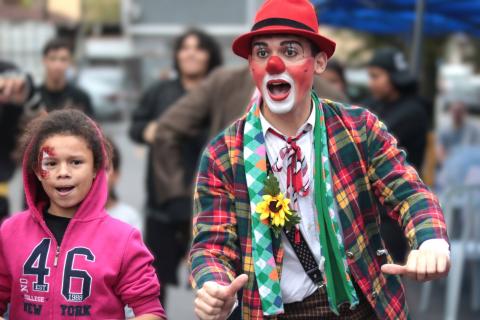 palhaço ao lado de criança  em feira livre. #paratodosverem