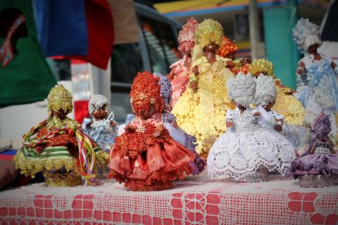 Artesanatos afros em cima de uma mesa. #paratodosverem