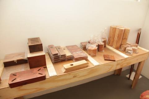 Diversos itens de madeiras espalhados em uma mesa grande de madeira.