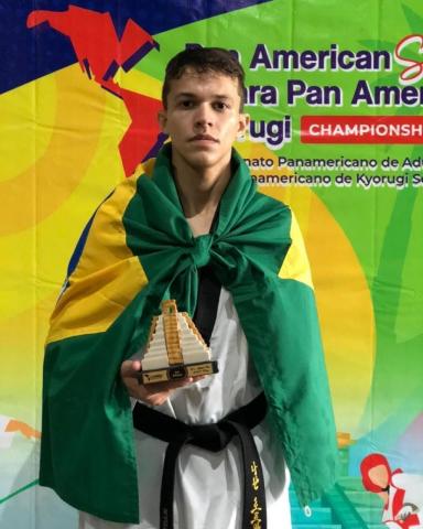 atleta enrolado na bandeira mostra troféu #paratodosverem