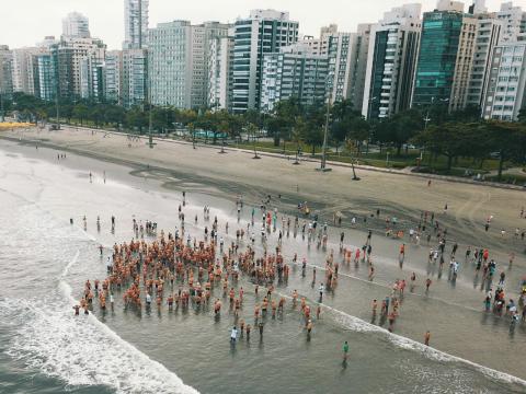 visão aérea dos atletas na praia #paratodosverem