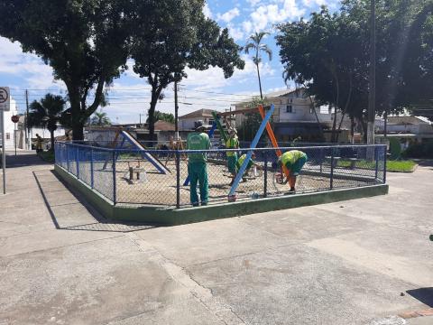 Operários fazem reparos em playground cercado. #paratodosverem