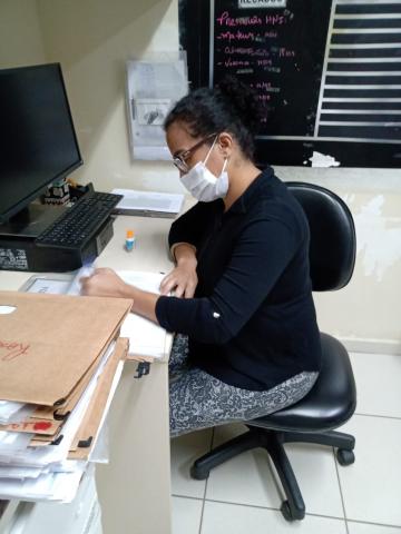 enfermeira em mesa anota em papel #paratodosverem