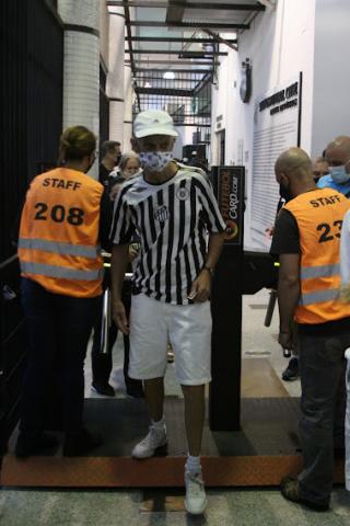 José Roberta entra no estádio. Atrás dele está a roleta e dois controladores de acesso. #paratodosverem