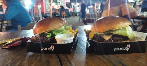dois hambúrgueres em embalagem sobre uma mesa. #paratodosverem