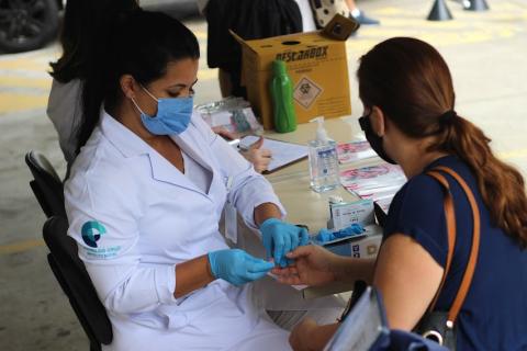 Enfermeira realiza teste de glicemia em mulher #paratodosverem