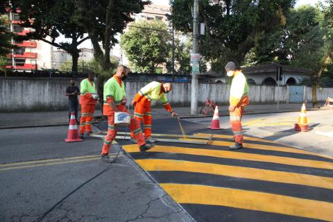 Homens pintando uma lombofaixa. #paratodosverem