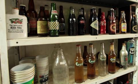 prateleiras com garrafas antigas de refrigerantes. #paratodosverem