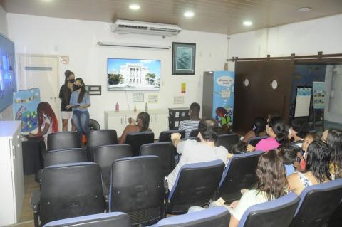 público sentado em poltronas do auditório do aquário. #paratodosverem