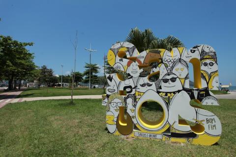 Monumento com vários pessoas e buraco em formato de ovo no jardim #paratodosverem