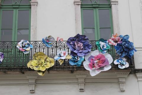 Rosas coloridas feitas de lona presas em varanda do Museu Pelé. #paratodosverem