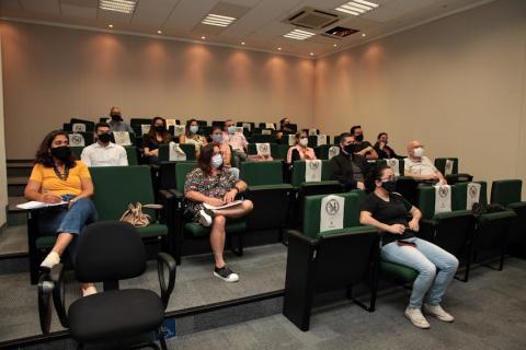 Pessoas acompanham oficina no auditório. #paratodosverem