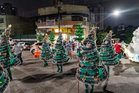 desfile de homens vestidos de árvore de natal. #paratodosverem