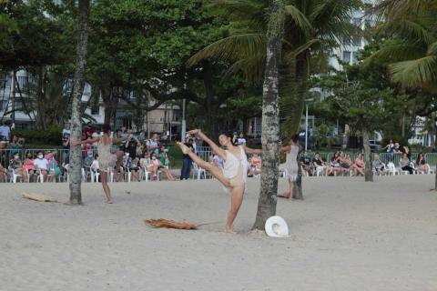 Bailarinas se apresentando na faixa de areia com publico assistindo sentado ao fundo #paratodosverem