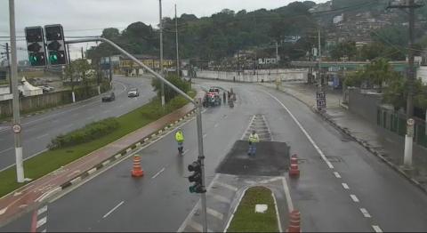 vista geral de avenida, com cones de controle de acesso no nas pistas. Dois agentes da CET estão no local, Ao fundo, viaturas da guarda municipal e CET. #paratodosverem