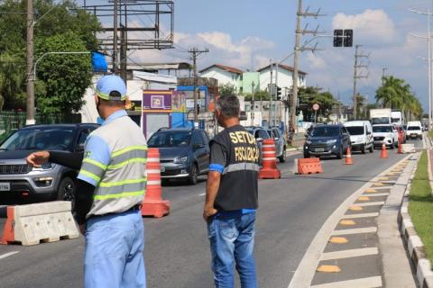 Operador de tráfego e fiscal da Prefeitura observam passagem de veículos em barreira sanitária. #pracegover