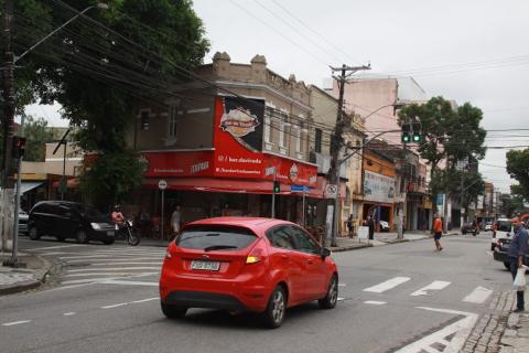 carro passando em rua com bar ao fundo  #paratodosverem