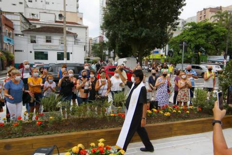 o pároco da igreja circula pela praça e acena para o público. #paratodosverem