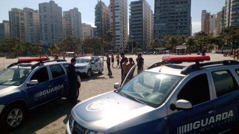 viaturas da guarda e da polícia militar na faixa de areia. Há pessoas em torno. #paratodosverem