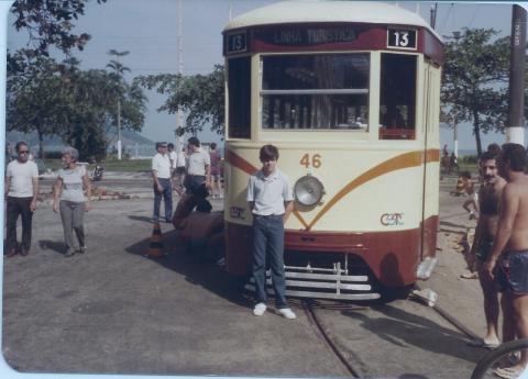 Jovem é fotografado na frente do bonde na orla. #paratodosverem