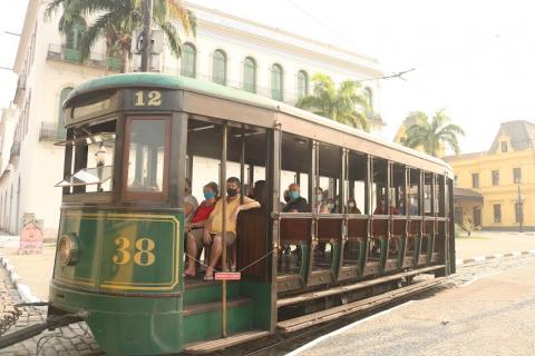 o bonde com passageiros passando diante do Museu Pelé. #paratodosverem