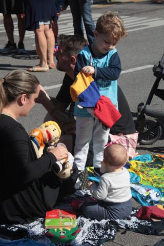 mulher, cirança e bebê estão sentados no chão mexendo em tecidos e bonecos. #paratodosverem