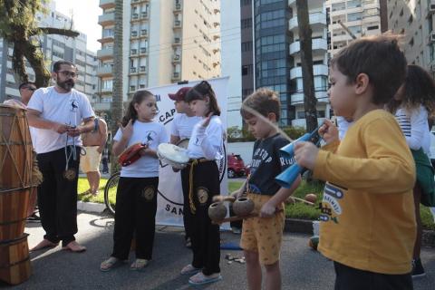 crianças tocam instrumentos típicos da capoeira. #paratodosverem