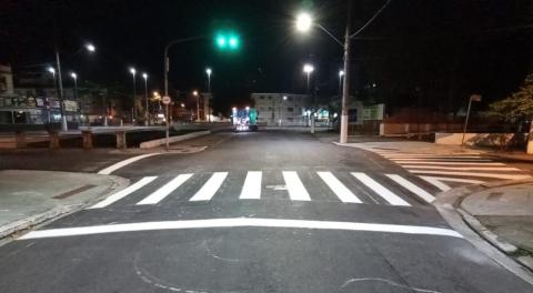 Imagem da via a noite com faixa de pedestre em primeiro plano #paratodosverem