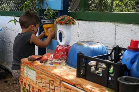 Criança mexendo em vasos no centro #paratodosverem