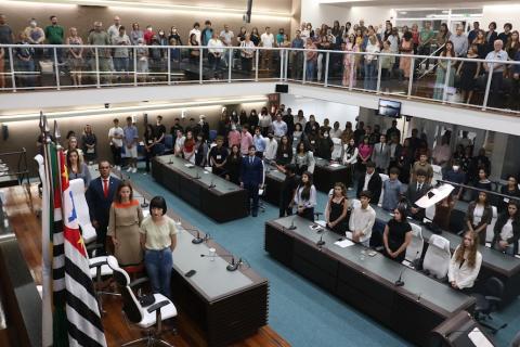 Jovens e autoridades em pé durante apresentação dos hinos. #pratodosverem