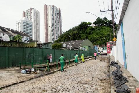Vista geral da rua e do canal, com homens trabalhando. #Paratodosverem