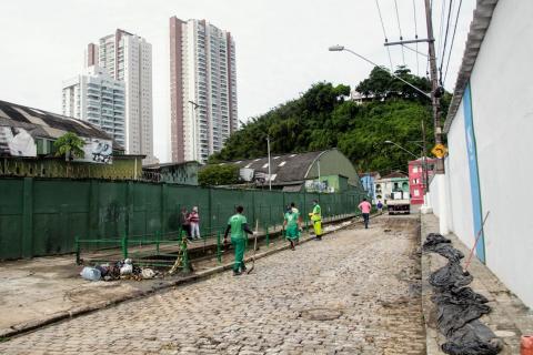 Vista geral da rua e do canal, com homens trabalhando. #Paratodosverem