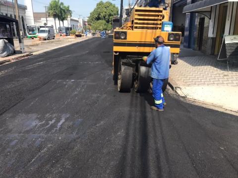 homem e máquina trabalhando em via. #paratodosverem