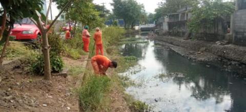 homens retiram mato de talude de canal. #paratodosverem