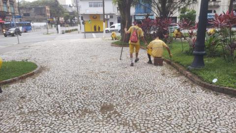 homens capinam trecho de praça. #paratodosoverem