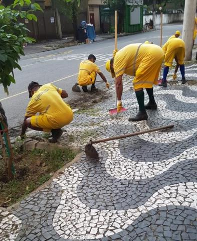 trabalhadores agachados realizando serviço na calçada #paratodosverem