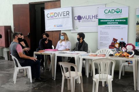 atendimento em assuntos de cidadania. Há banners pendurados na parede mencionando os serviços para mulher, orientação jurídica e outros. #paratodosverem