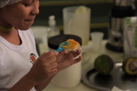 menina passa patê em pedaço de pão. #paratodosverem