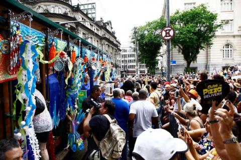 Bonde decorado em desfile de carnaval. Multidão ao lado. #paratodosverem