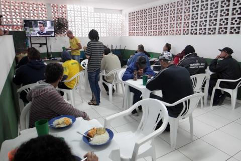 várias pessoas fazendo refeição em uma sala. #paratodosverem