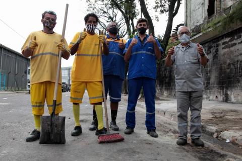 equipe de limpeza posa para foto com vassouras. #paratodosverem