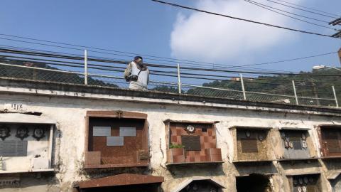 Homen instala cerca em cima do muro do cemitério. #paratodosverem