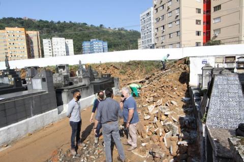 Profissionais conversam ao lado da obra dentro do cemitério. #paratodosverem