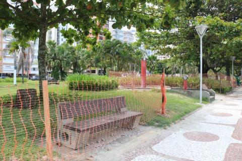 Cerca plástica instalada diante de jardim. Banco está atrás. #Paratodosverem