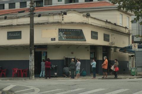 Fachada da Padaria Nova Bandeirantes com pessoas na porta. #paratodosverem