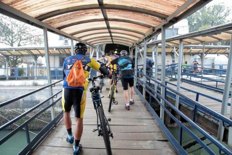 ciclistas percorrem trecho de desembarque da estação, um flutuante que liga a barca à terra. #paratodosverem