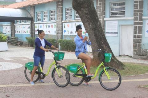 Dias mulheres andando de bicicleta na frente do Aquário. #paratodosverem