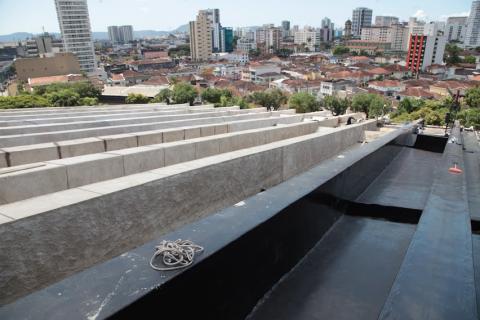 vista geral do telhado do teatro, com trecho impermeabilizado e outros no concreto. #paratodosverem